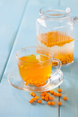 Vitaminic healthy sea buckthorn tea  with fresh raw sea buckthorn berries, selective focus, copy space