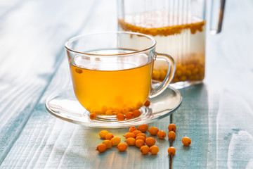 Vitaminic healthy sea buckthorn tea  with fresh raw sea buckthorn berries, selective focus, copy space