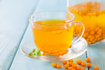 Vitaminic healthy sea buckthorn tea  with fresh raw sea buckthorn berries, selective focus, copy space