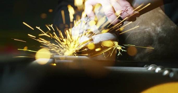 locksmith with a laser cuts in half a sheet of steel causing sparks.The laser heat Nicks iron up to get clean cuts and perfect for buildings with wrought iron.Concept: industry,technology,engineering.