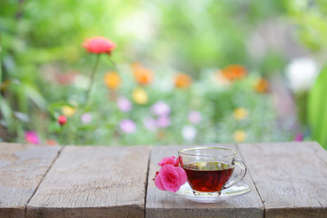 Tea glass and flower on wooden table at outside
