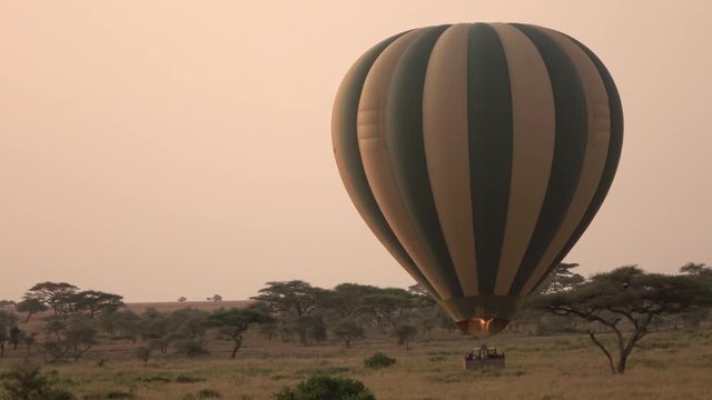 CLOSE UP: Tourists in safari balloon leaving the ground starting adventure