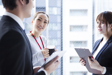Businessmen are taking a break at the window side of the office