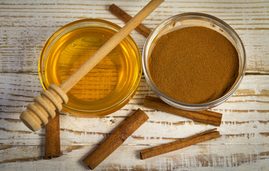 Honey and cinnamon on wooden background