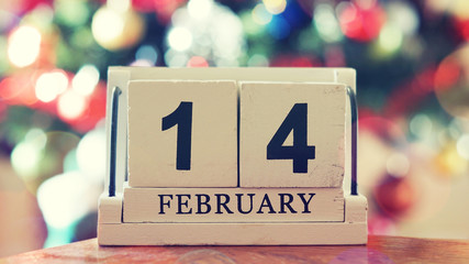 February 14 on wooden cube calendar on blur colorful bokeh backg