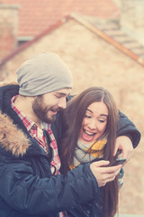 Obraz premium Couple using cellphone outdoors.