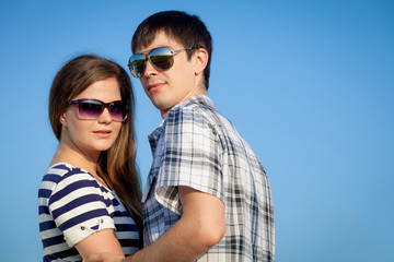 Portrait of young couple standing  in a field.