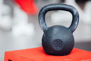 Naklejka na ściany i meble Large cast-iron sixteen pound weight dumbbell on gym .