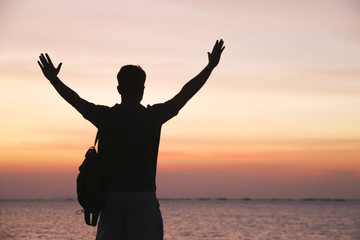 Stock Photo:.Man hiker silhouette walk on wet mole above sea to