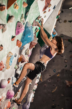  woman bouldering in climbing gym