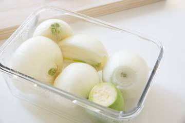 Fresh onion bulbs in a glass container