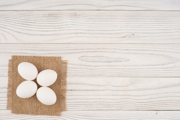 Chicken eggs on white old wooden table.