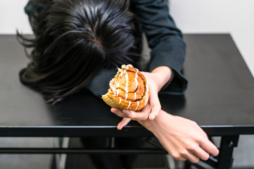 シナモンロールを食べて落ち込む女性