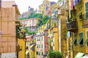 Fototapeta na wymiar Riomaggiore village, La Spezia, Liguria, northern Italy. Colourful houses on steep hills,castle with clock,laundry on balconies.Part of the Cinque Terre National Park and a UNESCO World Heritage Site.