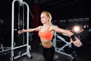 Fototapeta na wymiar young fitness woman demonstrate crossover exercises. The pectoral muscles, hard training with exercise-machine Cable gym