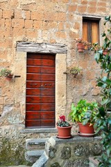 Fototapeta na wymiar vecchia porta in legno di un'abitazione nel borgo di Civita di Bagnoregio