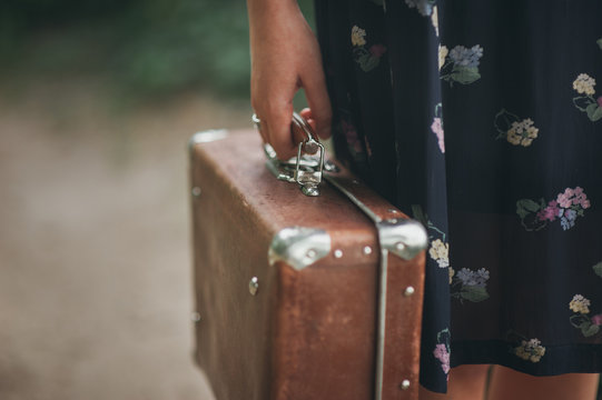 girl in a vintage dress holding suitcase
