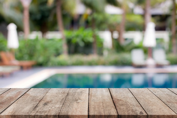 Wood table top and blurred swimming pool background. 