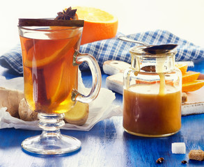 Ginger tea with orange in a glass cup.
