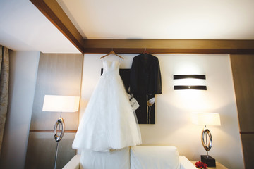 Fototapeta na wymiar Wedding dress of the bride and the groom's suit. Hotel. Hanging.