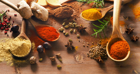 Various spices on a wooden board. - obrazy, fototapety, plakaty