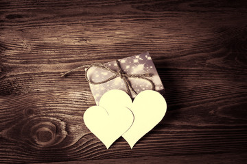 Holiday/romantic/wedding/valentine Day background with blank message card in the form of two hearts on wooden table. Retro style.