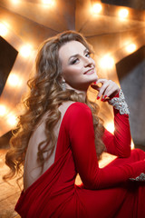 Beauty fashion portrait of elegant woman in red. Evening make-up and chic curls.