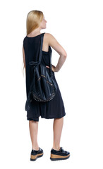 back view of standing young beautiful  woman.  girl  watching. Rear view people collection.  backside view of person.  Long-haired blonde with a leather backpack standing with hands on hips.