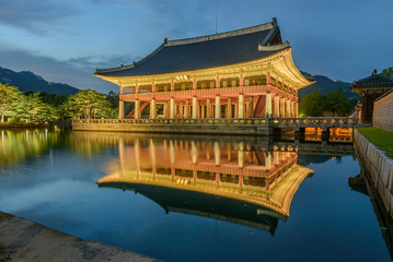 Naklejka premium Pałac Gyeongbokgung nocą w Korei Południowej, z nazwą pałacu „Gyeongbokgung” na znaku