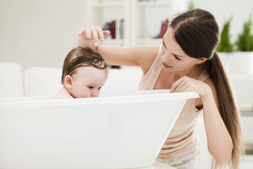 Obraz na płótnie Canvas Mother Bathing Her Baby