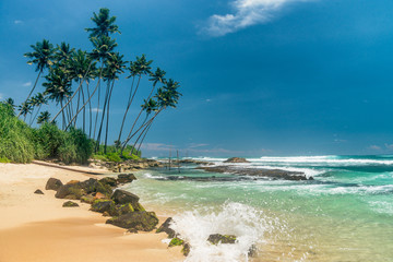 Sunny beach near Koggala - Sri Lanka. Waves of clear water and warm sand 
