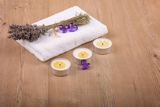 Spa decoration /
Still life with dry lavender, candles and a white towel on a wooden background