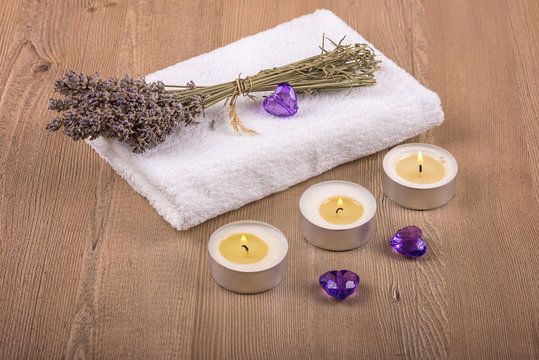 Spa decoration /
Still life with dry lavender, candles and a white towel on a wooden background