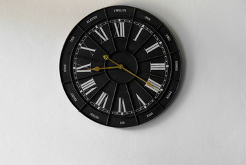 vintage black-white clock with a roman number on the white backg