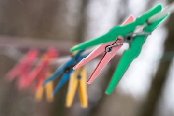  Plastic, colorful clothes pegs hanging on the wire