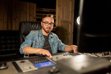 man at mixing console in music recording studio