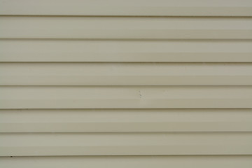Corrugated sheet fence made of beige metal sheets without screws.