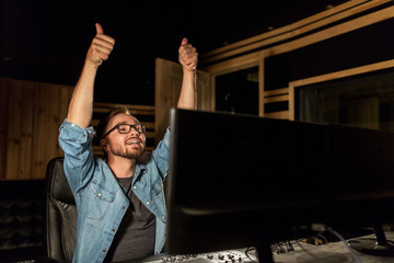 man at mixing console in music recording studio