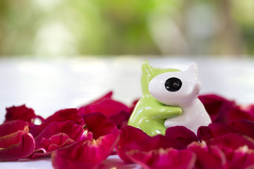 Two Dog tile doll in love on pile of rose petals
