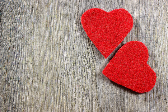 A two decorative red hearts on gray wooden background
