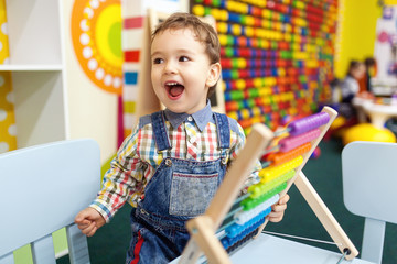 Happy little boy learning to count on abacus.