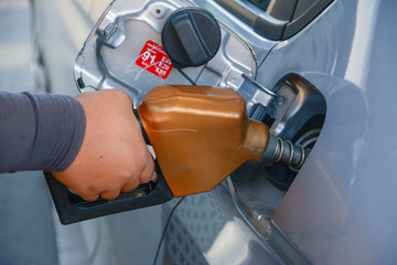 holding fuel nozzle and refuel car  in gas station