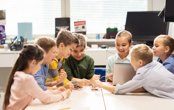 happy children with laptop at robotics school