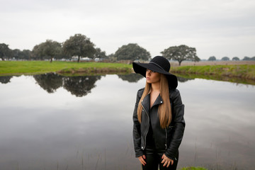Obraz premium Stylish young woman with beautiful hat in the field