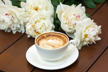 Coffee with flowers on wooden table