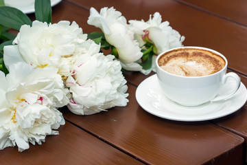 Coffee with flowers on wooden table