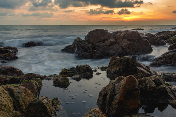 Fototapeta na wymiar beach sunset long exposure beautiful shore rocks coral waves water ocean