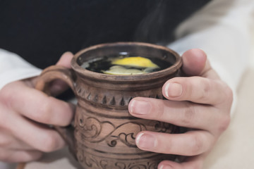 Fototapeta na wymiar Hot useful fragrant tea in the morning in his hands