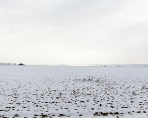 The gloomy winter sky over the snowy field.