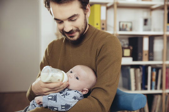 Father feeding his baby at home
